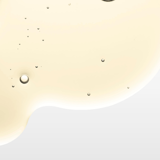 Close-up of a glass of white wine with bubbles on a light background