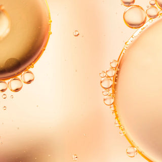 Close-up of oil droplets on a peach-colored background