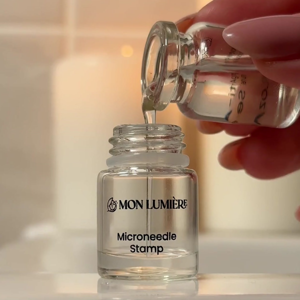 Person pouring liquid from a small bottle into a MON LUMIØRE Microneedle Stamp container.